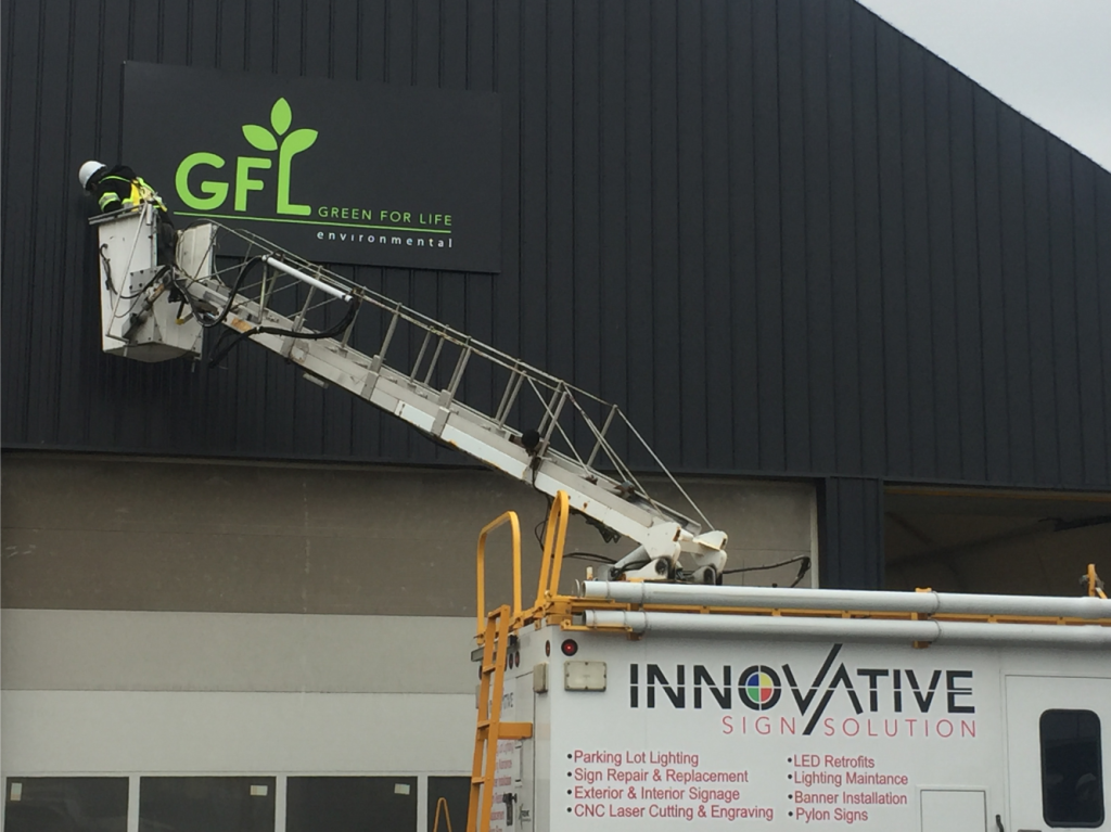 Innovative Sign Solution technician installing large GFL Environmental exterior business sign using a bucket truck Exterior GFL Sign Pickering Plant