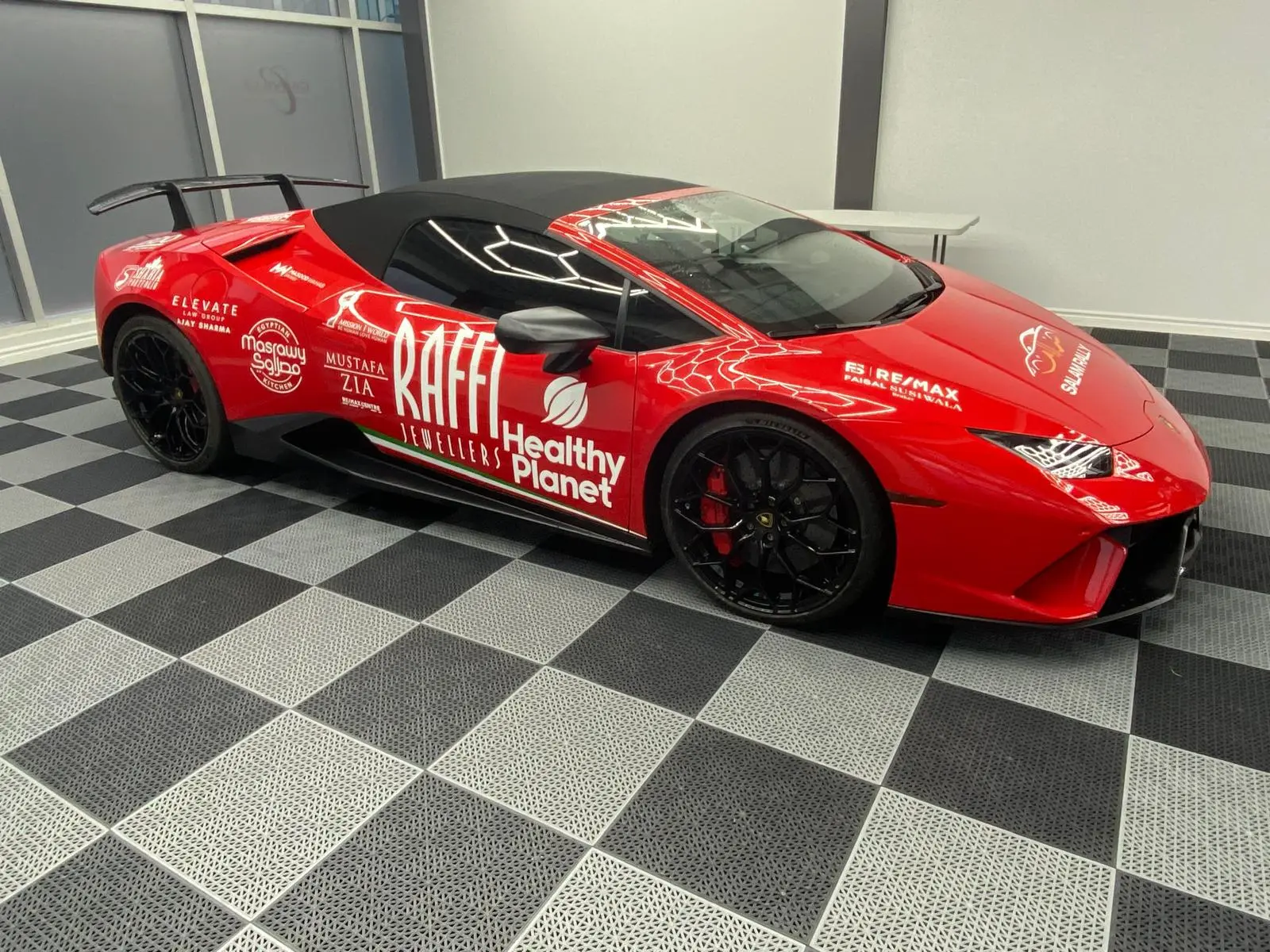 Lamborghini sports car with red sponsorship wrap designed by Innovative Sign Solution, Fleet Graphic Branding and Vehicle Wraps in Toronto, Mississauga, Brampton, Vaughan, Hamilton, Oakville, London, and Southern Ontario.